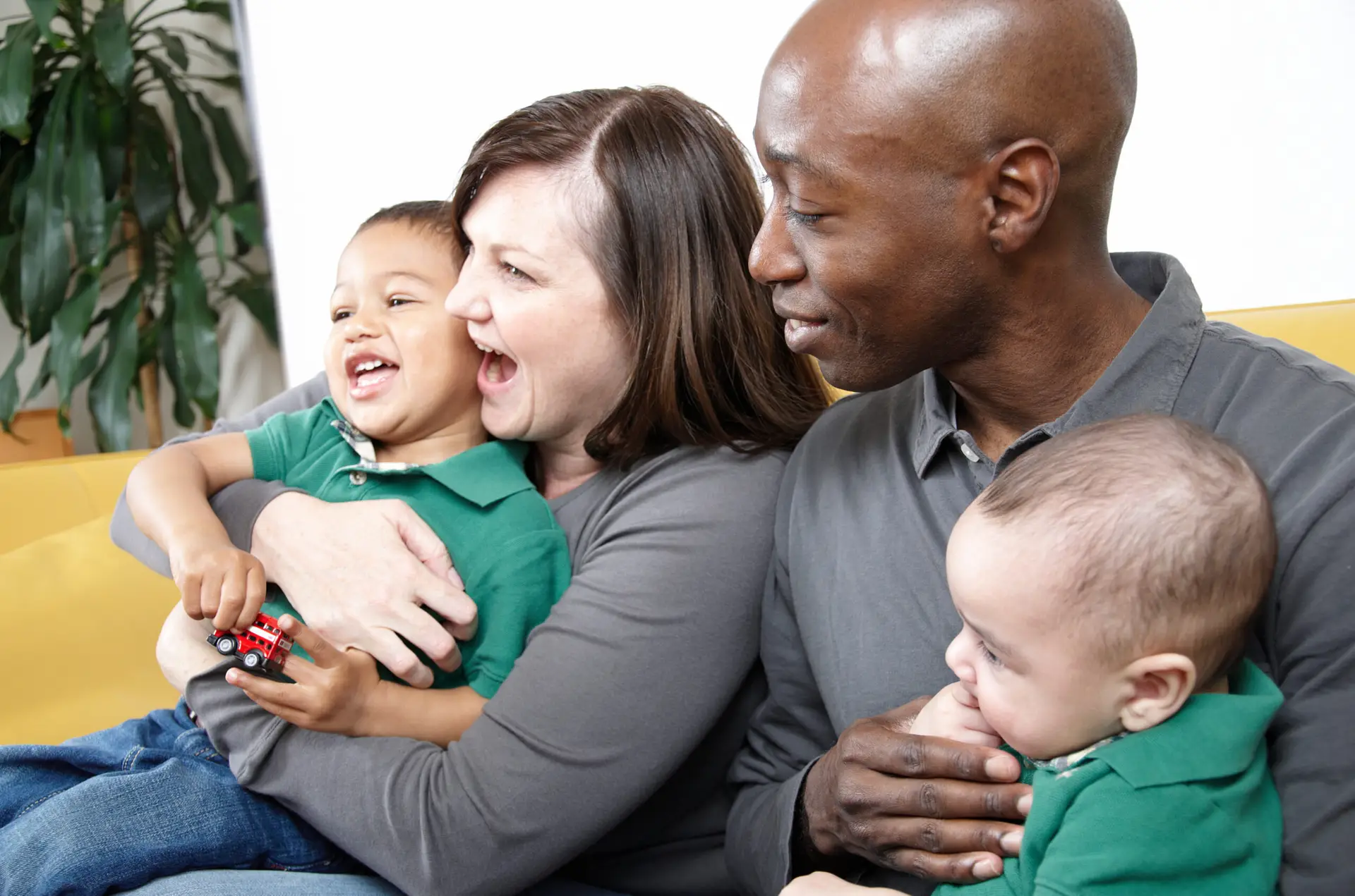 Multi racial family seated and enjoying some entertainment together.